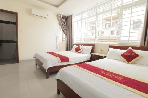 ブンタウにあるThảo Nguyên Hotelのベッドが2つと窓があるホテルの部屋