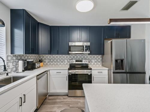 a kitchen with dark blue cabinets and stainless steel appliances at 962 Z2B VILLAGE OF EL CORTEZ by REMAX Premier in Lady Lake