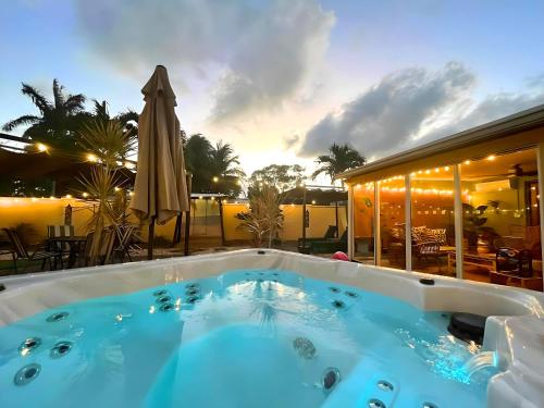 a large hot tub in a patio with an umbrella at Fun Getaway: Hot Tub, Tiki Bar, Arcade Room in Hollywood