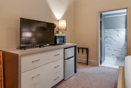 a living room with a flat screen tv on a dresser at Quaint Retreat for 2 Heart of DT Near Broadway in Nashville