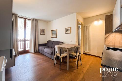 ein Wohnzimmer mit Tisch und Couch in der Unterkunft Maison Amel - Poluc Apartments bilocale in Champoluc
