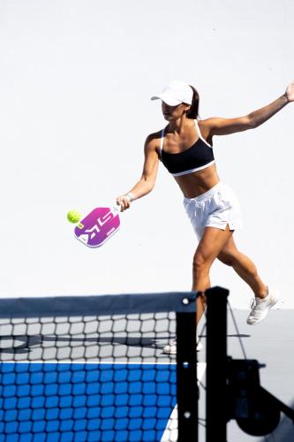 a woman jumping over a volleyball net at Casa Nawalli Pickleball Resort & Retreats Adults Only in Sayulita