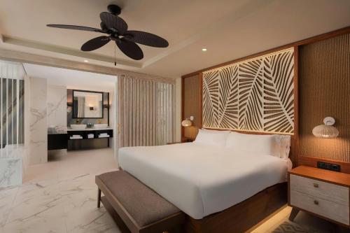 a bedroom with a large white bed with a ceiling fan at Four Points by Sheraton Costa Blanca Resort in Benidorm