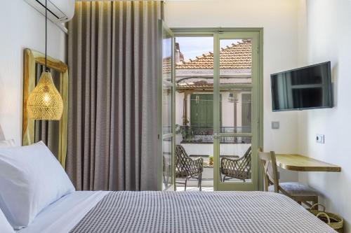 a hotel room with a bed and a balcony at Skopelos Prime Central Stays in Skopelos Town
