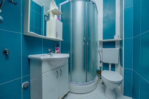 a blue bathroom with a toilet and a sink at Vanila Apartmani in Sutomore