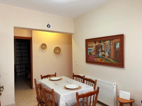 a dining room with a table and a painting on the wall at Villa Geomare in Apolakkiá