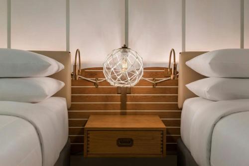 a room with two beds and a chandelier between them at Newport Marriott Hotel & Spa in Newport