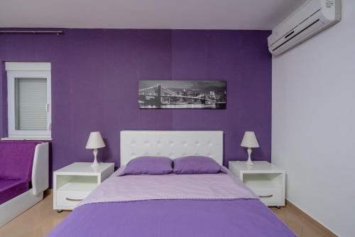 a purple bedroom with a large bed with purple walls at Vanila Apartmani in Sutomore