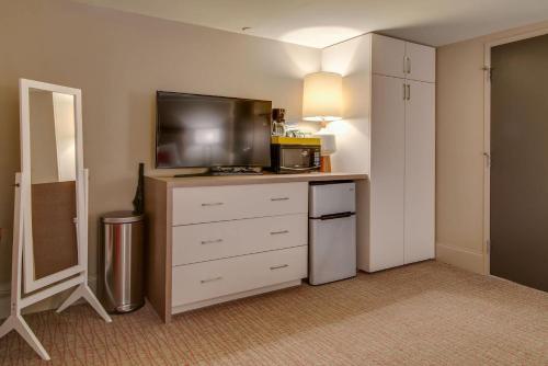 a hotel room with a television and a dresser with a dresser at Cozy Retreat for 2 Heart of DT Near Broadway in Nashville