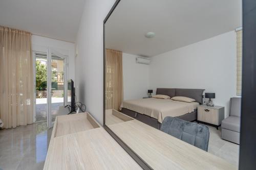 a bedroom with a bed and a large mirror at Vanila Apartmani in Sutomore