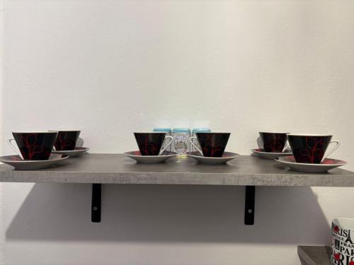 a table with four cups and bowls on it at Guest house Elina in Kalívia Thorikoú