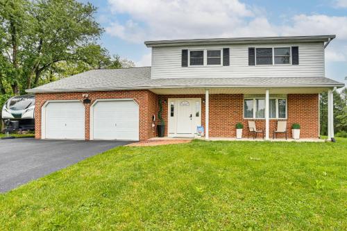 a brick house with two white garage doors at Hersheypark 6 Mi Away Family Getaway with Fire Pit in Palmyra