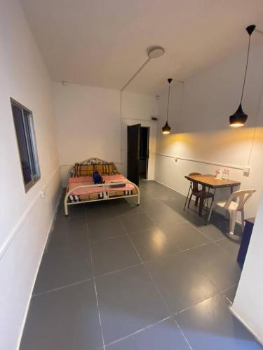 a bedroom with a bed and a table in a room at Combretrata in Phnom Penh