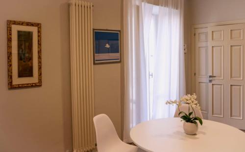a white table and chairs in a room with a window at Casa Bebella in Senigallia