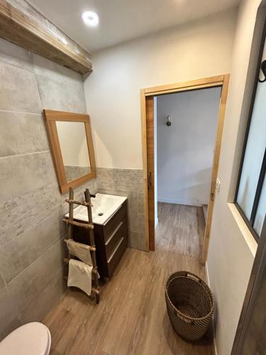 une salle de bain avec un lavabo et un miroir dans l'établissement La Grange, à Bayonne