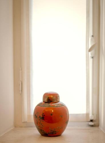 an orange vase sitting in front of a window at Casa Bebella in Senigallia
