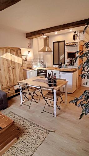 une cuisine avec une table et des chaises dans une pièce dans l'établissement La Grange, à Bayonne