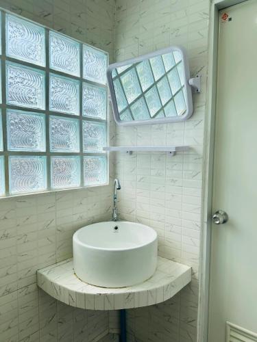 a white bathroom with a sink and two windows at Hotel4U Koh Tao in Ko Tao