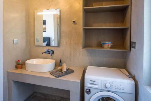 a bathroom with a sink and a washing machine at Michalis-Nina studios in Livanianá