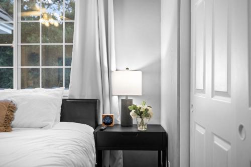 a bedroom with a bed and a table with a lamp at Sprawling Escondido Estate Garden Pool Games ADU's in Escondido