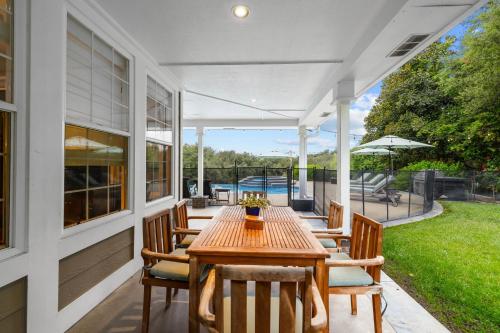 a patio with a wooden table and chairs at Sprawling Escondido Estate Garden Pool Games ADU's in Escondido
