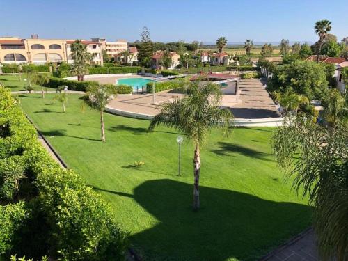 a park with palm trees and a swimming pool at Basilicata Host to Host - La Conchiglia in Metaponto