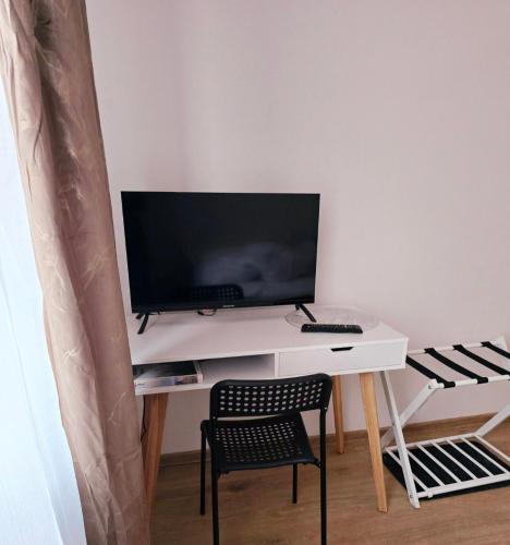 a white desk with a monitor and a chair at Perłowy in Biłgoraj