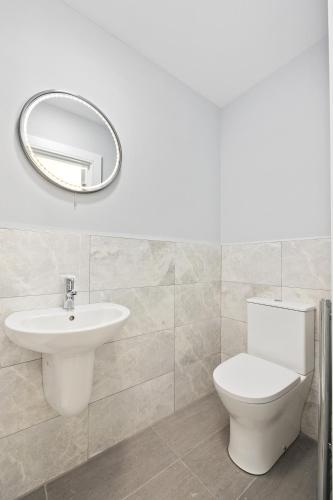 a bathroom with a toilet and a sink and a mirror at North Dublin Homestay in Dublin