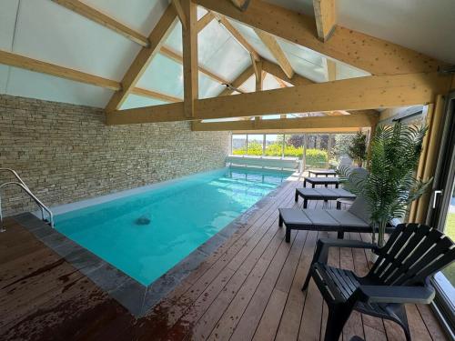 - une piscine dans un bâtiment avec une terrasse en bois dans l'établissement Le Cap Ouest, à Barneville-Carteret