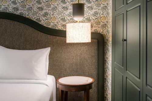 a bedroom with a bed and a table next to a door at AC Hotel Ciudad de Sevilla by Marriott in Seville