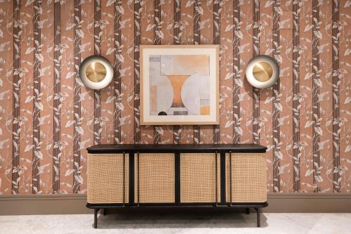 a table in front of a wall with a picture at AC Hotel Ciudad de Sevilla by Marriott in Seville