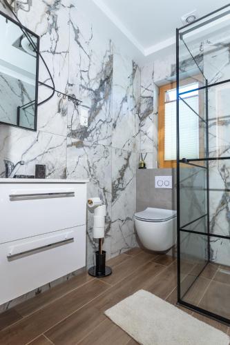 a bathroom with a white sink and a toilet at Domki Stochowa Śleboda in Bukowina Tatrzańska