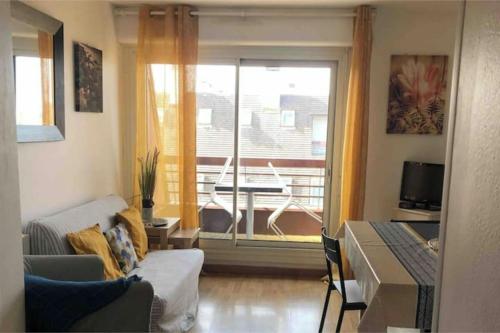 un salon avec un canapé, une table et une fenêtre dans l'établissement Superb flat with sea views, à Houlgate