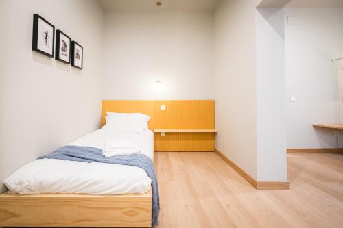 a bedroom with a bed with a yellow headboard at OLBLANC Plaza de España by Batuecas in Madrid