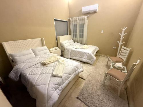 a hotel room with two beds and a chair at مفتاح الحياه in Banī Ghālib