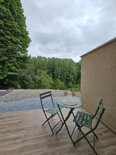 une table et deux chaises assises sur une terrasse dans l'établissement Location Hauterives, à Hauterives