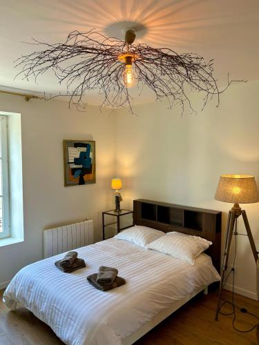 une chambre avec un lit avec deux chapeaux dessus dans l'établissement Studio centre-ville entièrement rénové, à Mortagne-au-Perche