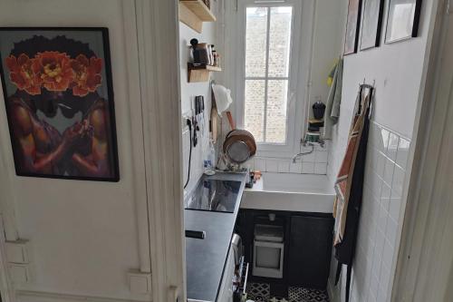 La cuisine est équipée d'un évier, d'une cuisinière et d'un réfrigérateur. dans l'établissement Apartment 2 rooms near Bastille, à Paris