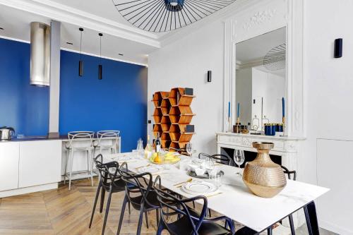 une salle à manger avec une table et des chaises blanches dans l'établissement appartement de Luxe haussmannien aux champs-elysees, à Paris