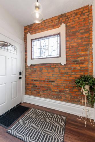 an empty room with a brick wall and a door at Steps 2 High ST - BIG Patio - Private parking- OSU in Milo