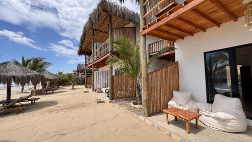 a resort on the beach with chairs and tables at Baja Canoas Hotel in Canoas De Punta Sal