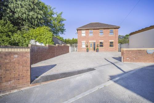 an empty driveway in front of a brick building at Coach House in Bridgend