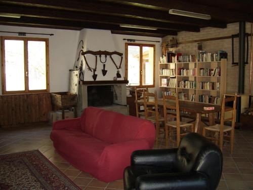a living room with a red couch and a fireplace at Agriturismo Mulino di Culmolle in Raggio