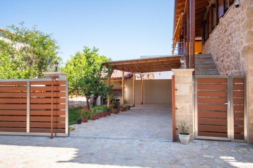a wooden fence in front of a building with stairs at Dionysis Elegant Cozy Apartment in Filiatra