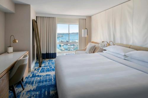 a hotel room with a large white bed and a desk at Newport Marriott Hotel & Spa in Newport