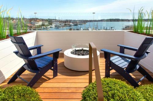 a patio with two chairs and a fire pit on a deck at Newport Marriott Hotel & Spa in Newport