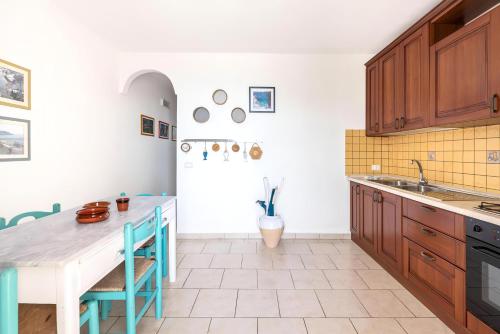 a kitchen with wooden cabinets and a table at Terrazza fronte Mare in Castro di Lecce