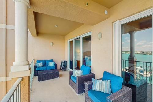 a balcony with blue chairs and windows with the ocean at Harborview Grande 402 in Clearwater Beach