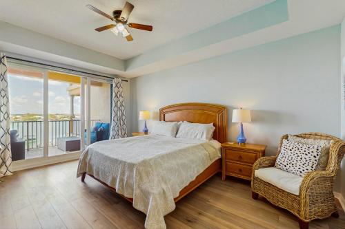 a bedroom with a bed and a chair and a window at Harborview Grande 402 in Clearwater Beach