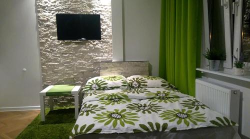 グディニャにあるApartament GDYNIAKのベッドルーム1室(ベッド1台、壁掛けテレビ付)